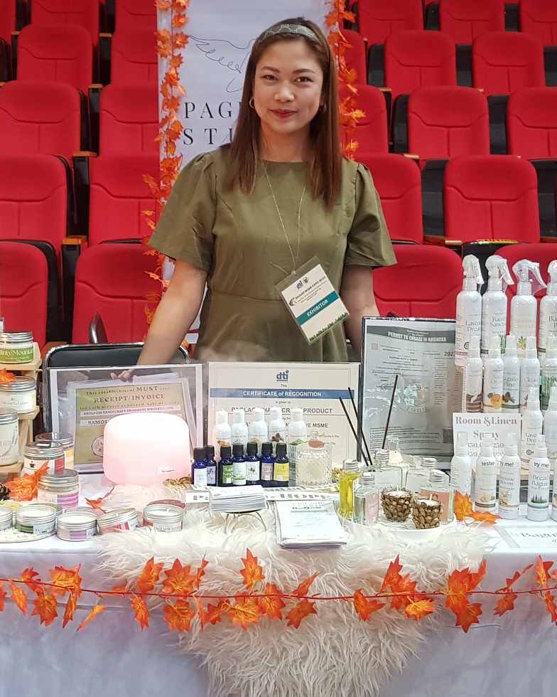Ruth Maclang at Paglaom Studio booth displaying handpoured candles and scented products from Baguio City